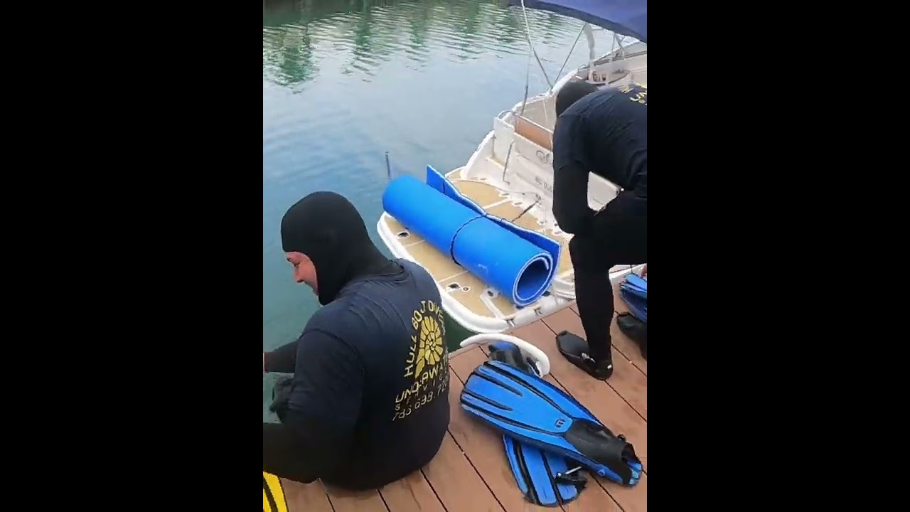 Limpieza de cascos de barcos en el agua por buzos asegurados y de experiencia