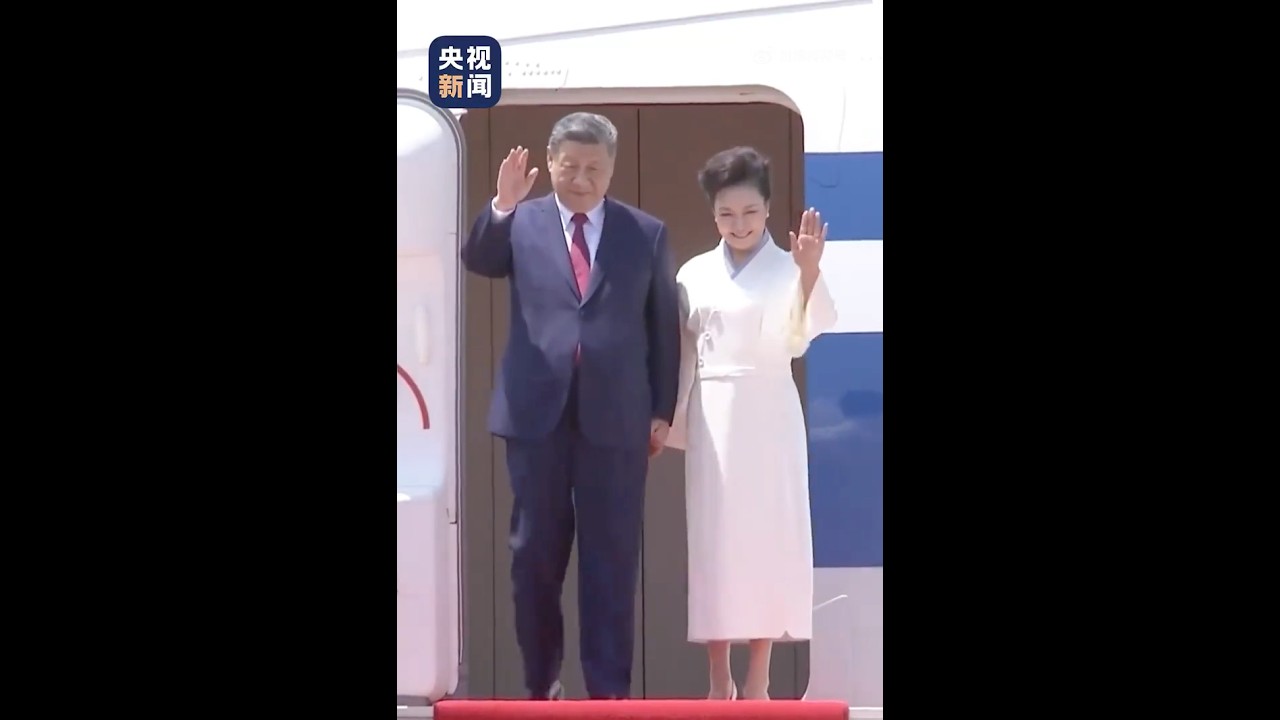 President Xi Jinping and wife Peng Liyuan waving to welcoming people upon arrival in Pyongyang