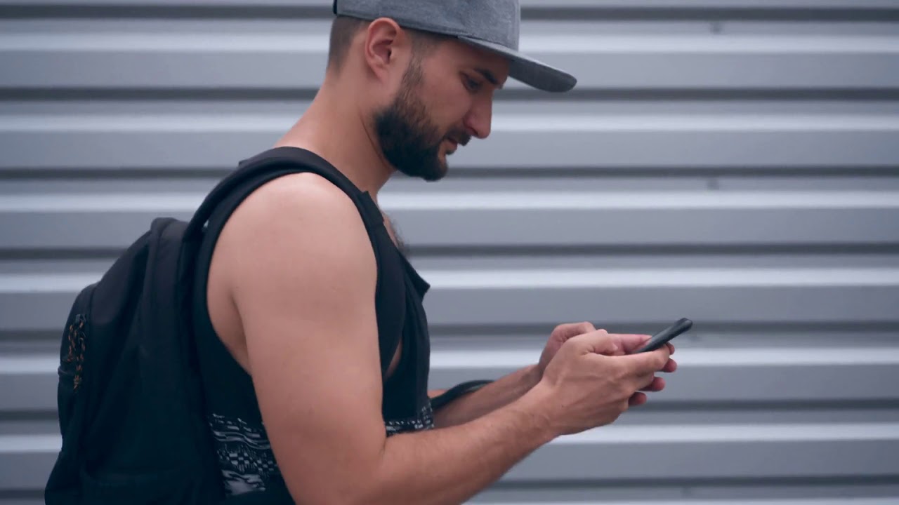 busy modern bearded man texting on phone while walking at street