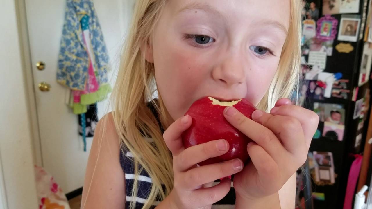 Ella tries to pull loose tooth by eating apple