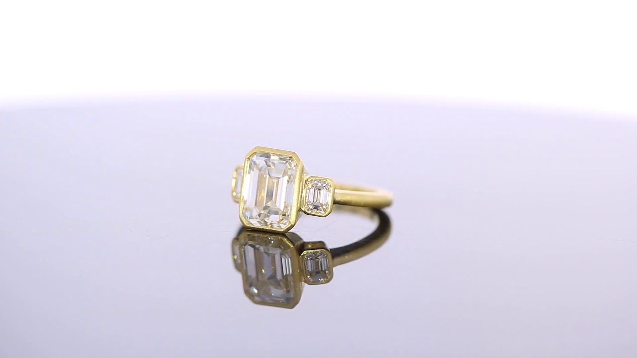 Stunning Bezel Set Three Stone Emerald Cut Engagement Ring with Side Stones