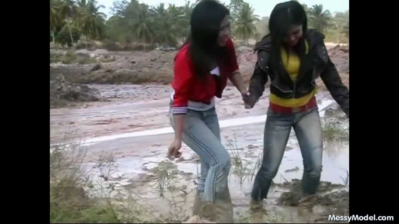 2 Thai girls get wet and muddy in a gravelpit.