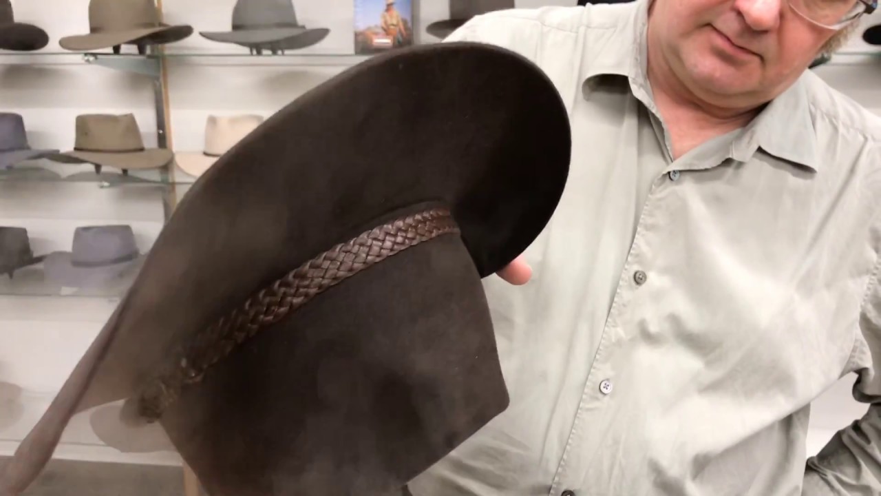 Lifting the crown of a fur felt hat like the Akubra Overlander, Cattleman, or Snowy River.