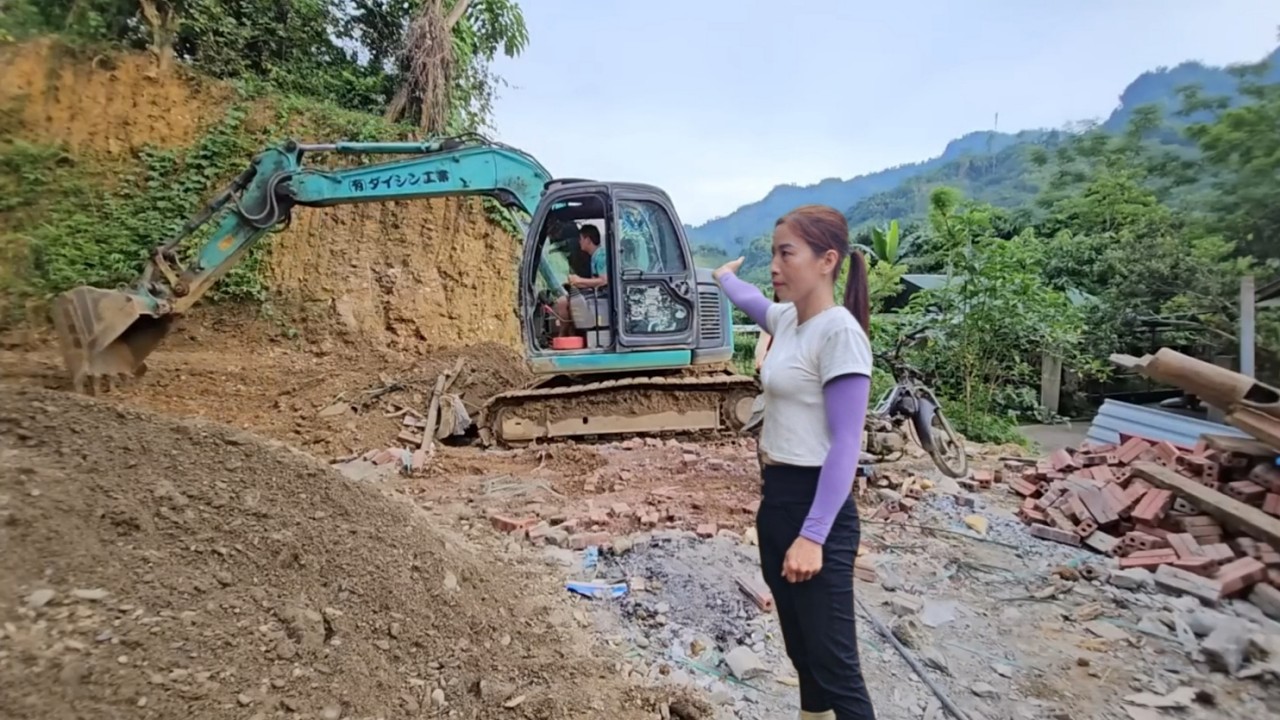 Excavator digging and leveling the ground for garden painting.