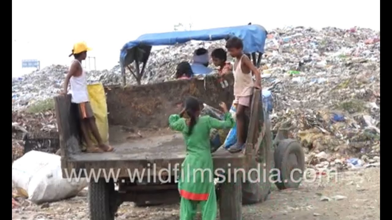 Children with adults ragpicking at a garbage dump site - Children playing with plastic waste