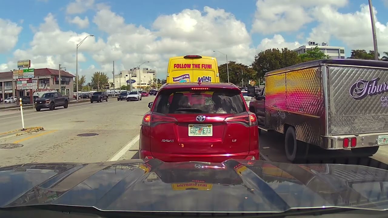 Driving down NW 36th Street in Miami with heavy traffic on a Wednesday afternoon.