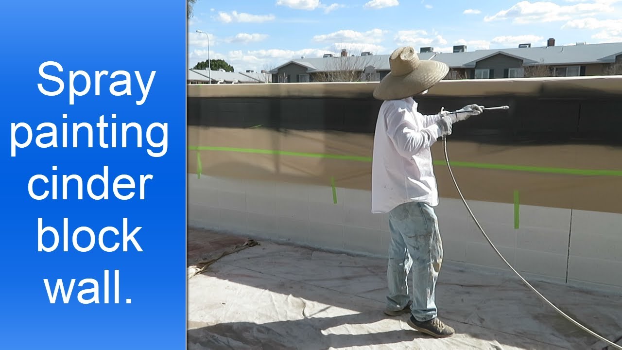 Spray painting cinder block wall.