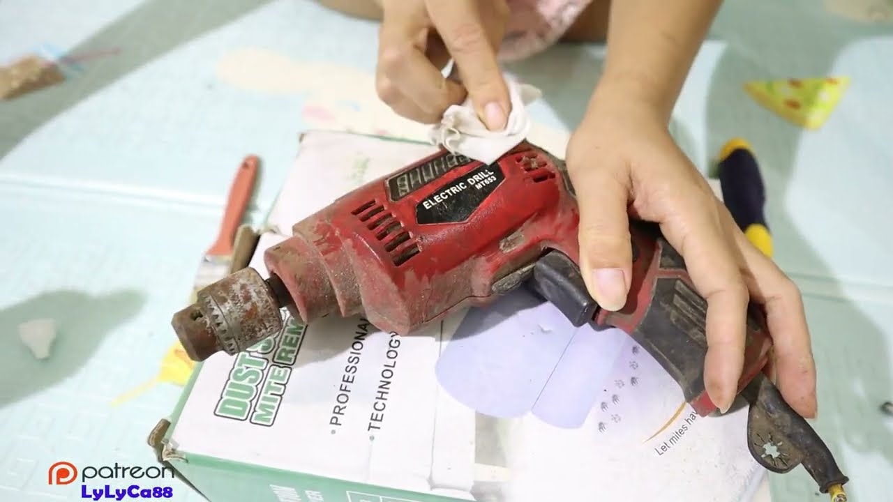 The girl with golden hands repairs a hand drill that has been broken for a long time