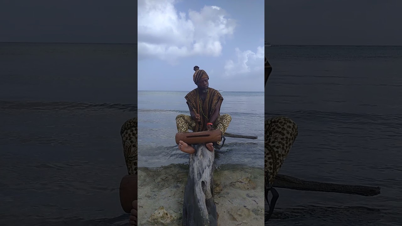African musician playing the krin on the Caribbean Sea