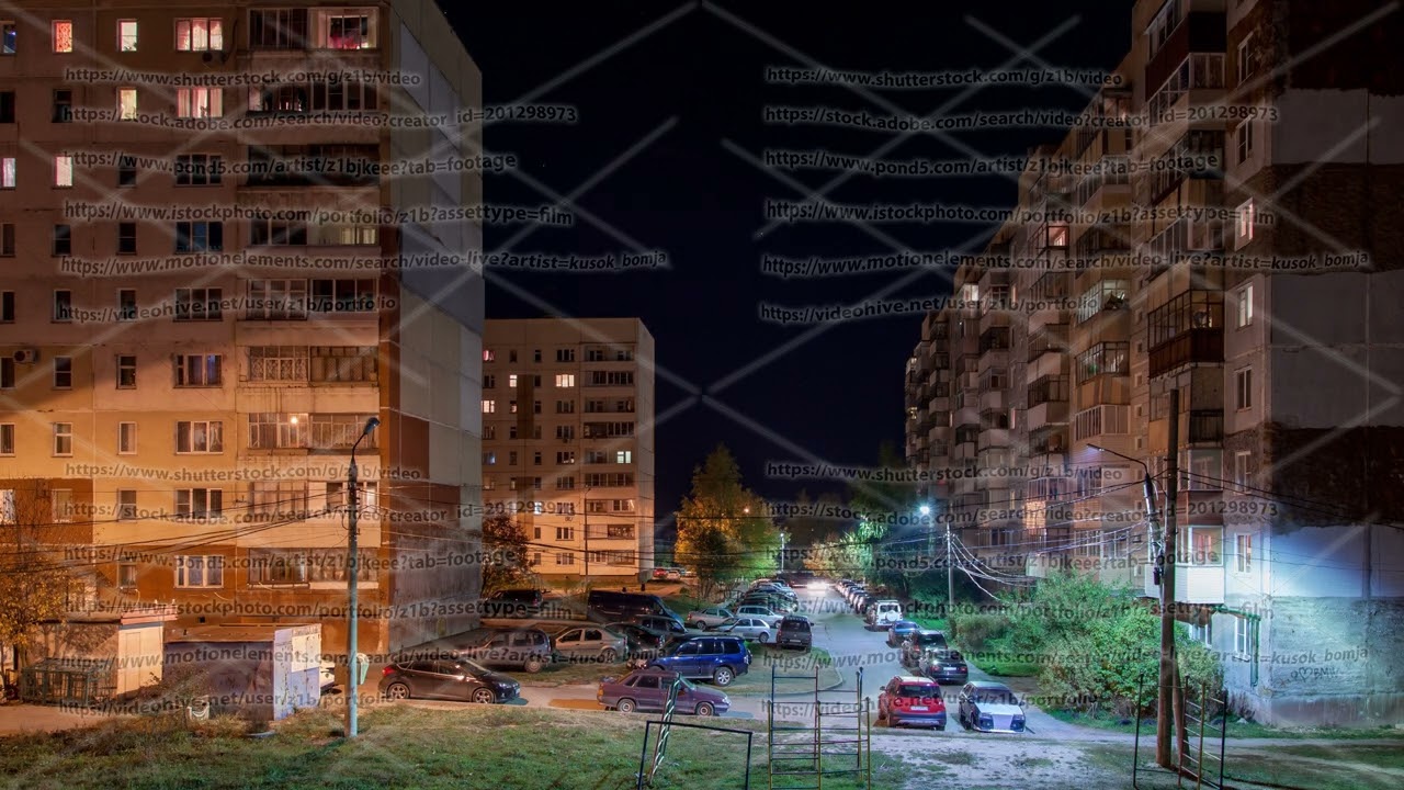 Time-lapse of night russian suburban street parking between apartment buildings at autumn time