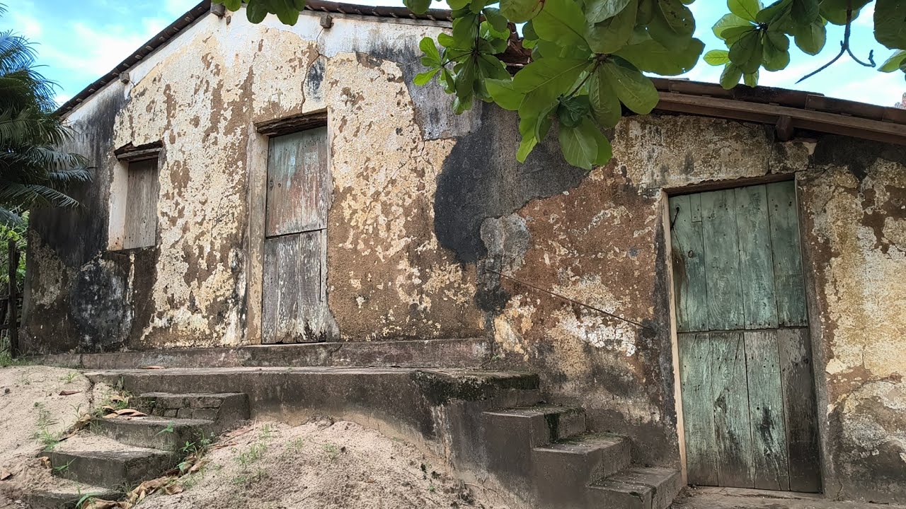 Casa muito antiga, com muitas riquezas ao seu redor. 