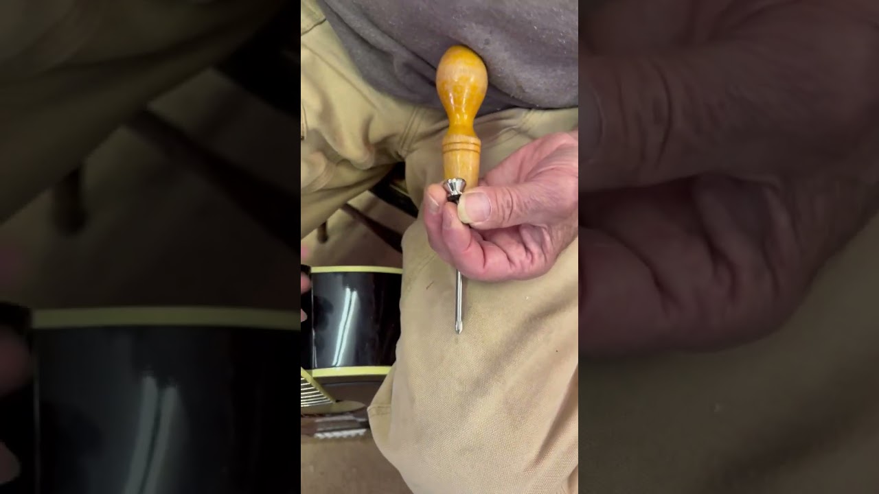 Professional luthier installing a strap button on a Gibson Southern Jumbo guitar