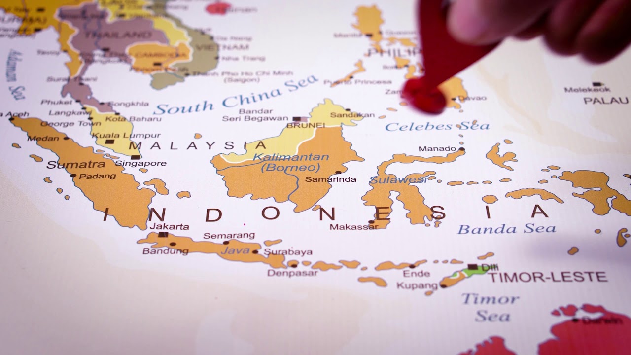 A person is placing 3d printing location GPS icon on map of Indonesia Travel Visit and Discover Indo