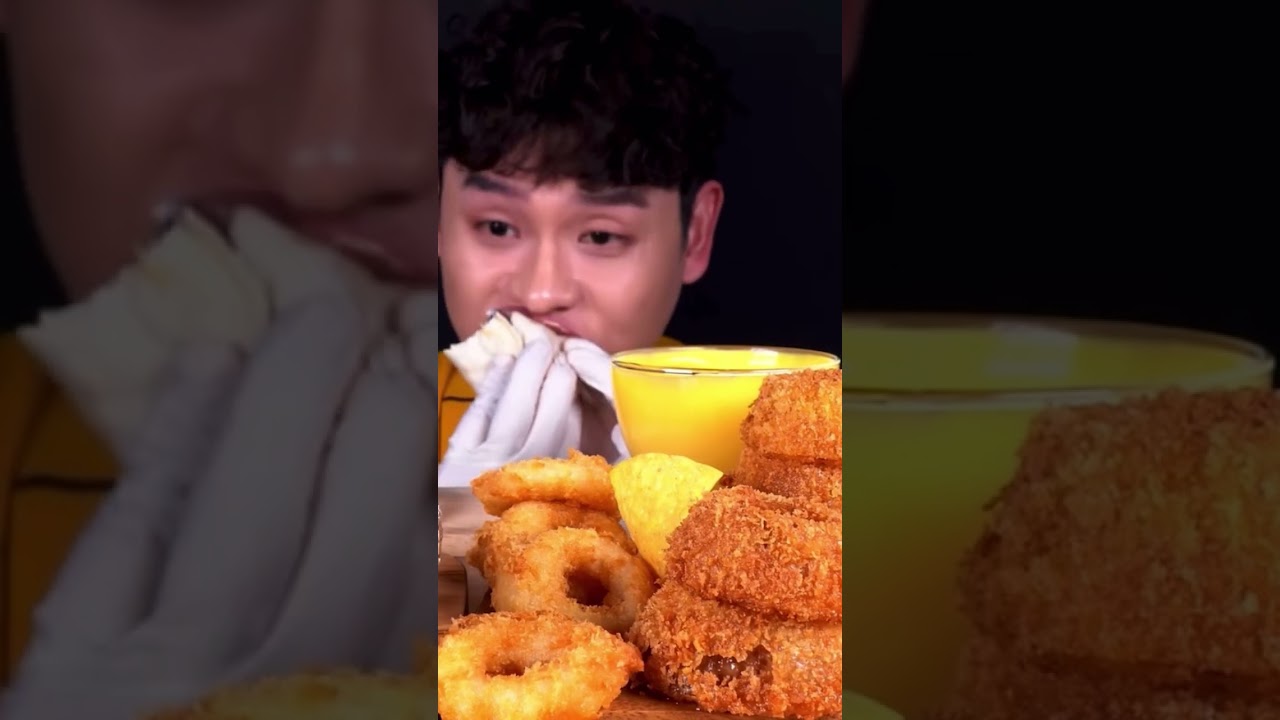Crunchy bites of burrito, fried onion rings and nachos with nacho cheese by bonggil
