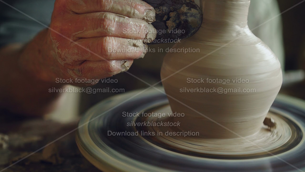 Work in pottery workshop: clay ware on throwing wheel, master ceramist molding clay using tools