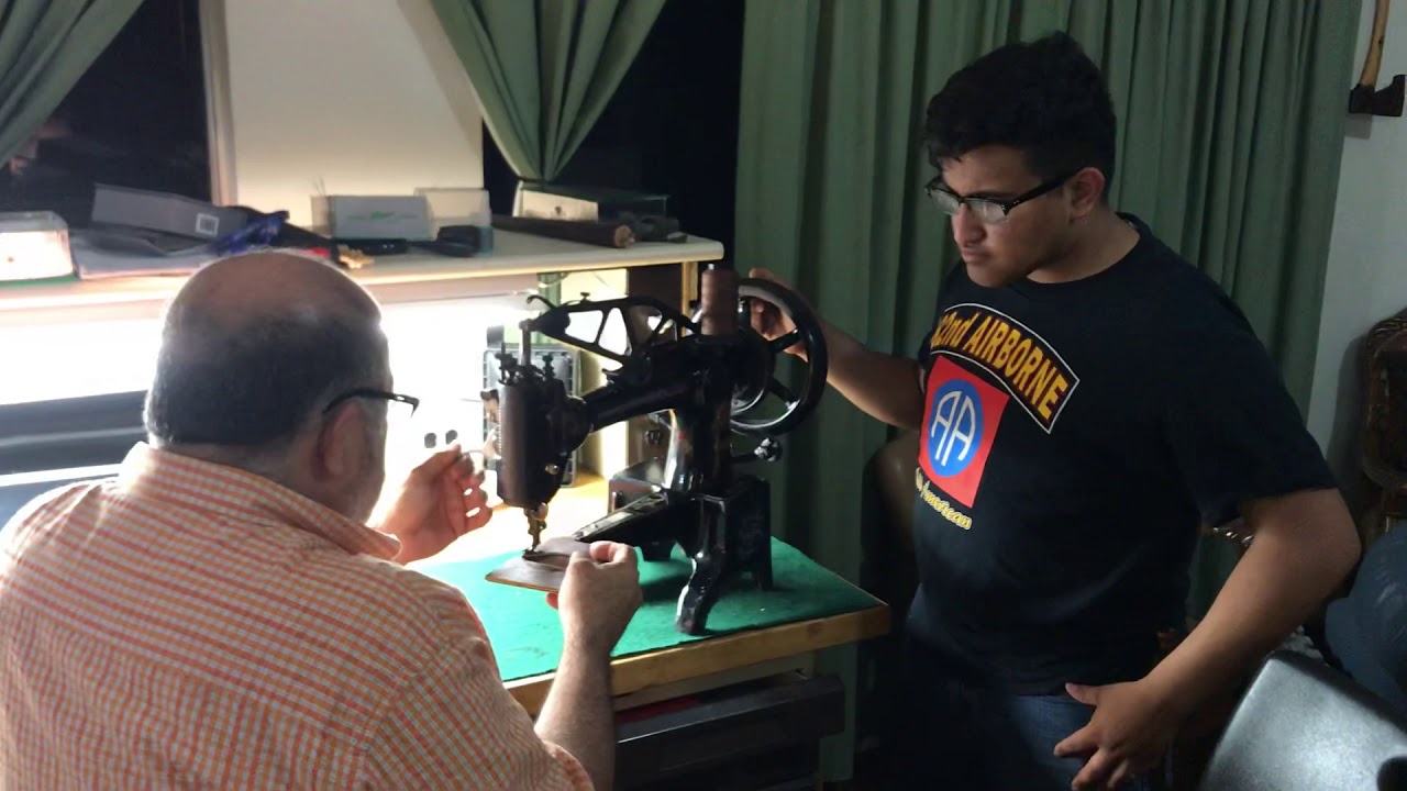 Gabriel Michael uses antique Singer 29K making a leather wallet.