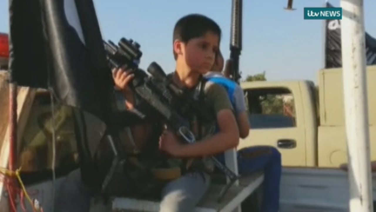 Children armed with rifles parade in ISIS convoy through Mosul