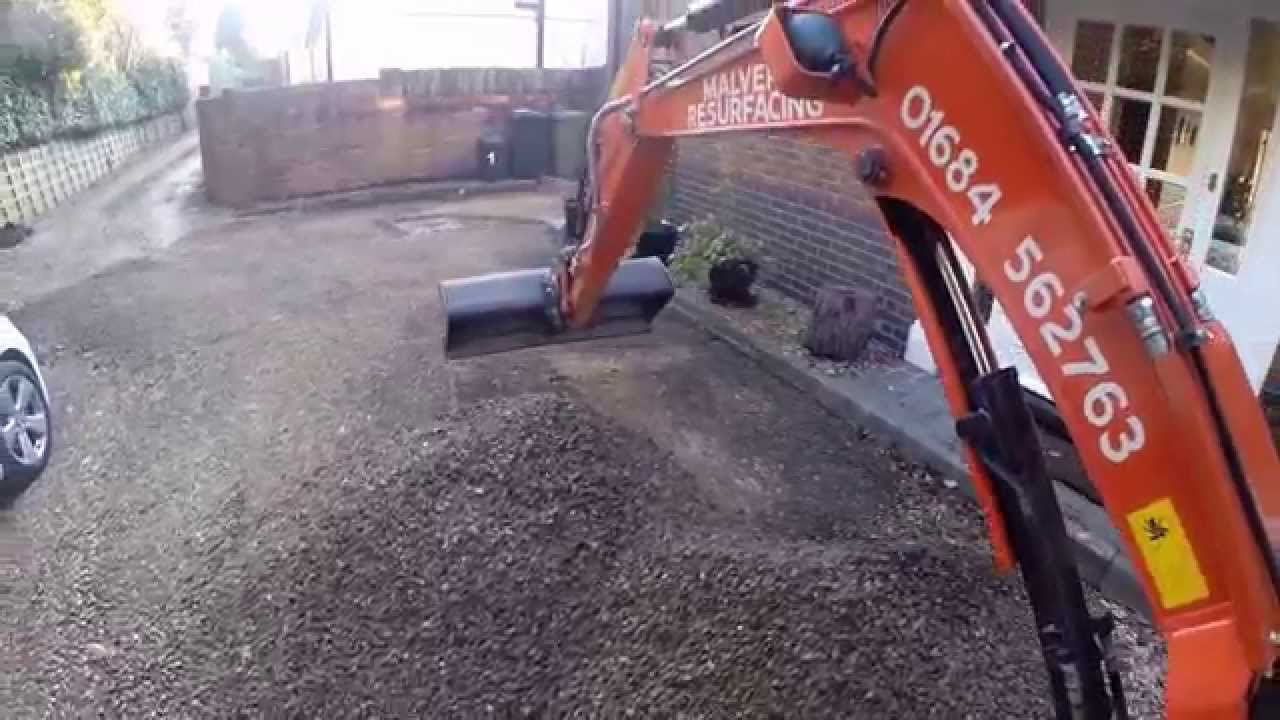Mini Excavator Removing Gravel Off A Driveway