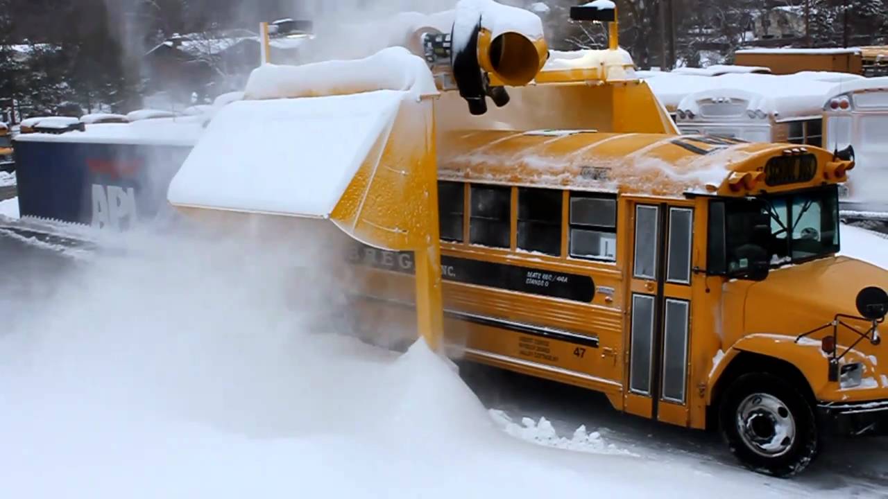 School bus going through snow blower