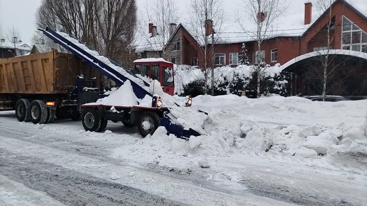 Лаповый снегопогрузчик ко206 грузит глыбы снега.