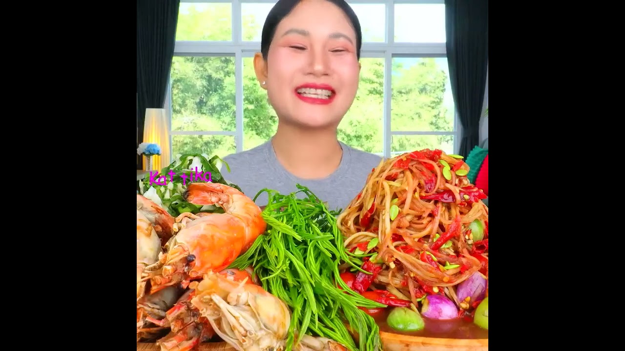 Eating spicy papaya salad with fresh, sweet crab, chewy rice noodles, acacia leaves, and spiciness