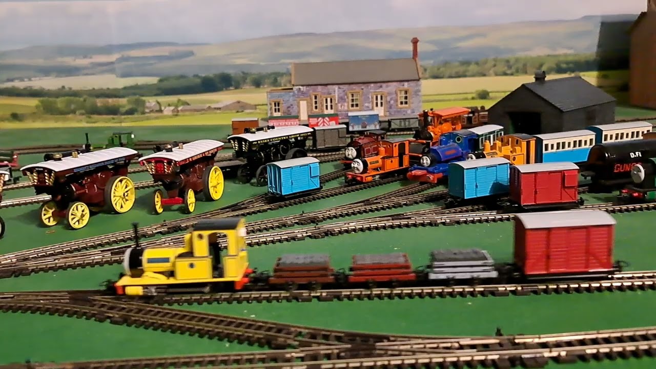 Bachmann Yellow Rheneas pulling 1 brown, 1 red, 1 grey slate wagons and red box van 