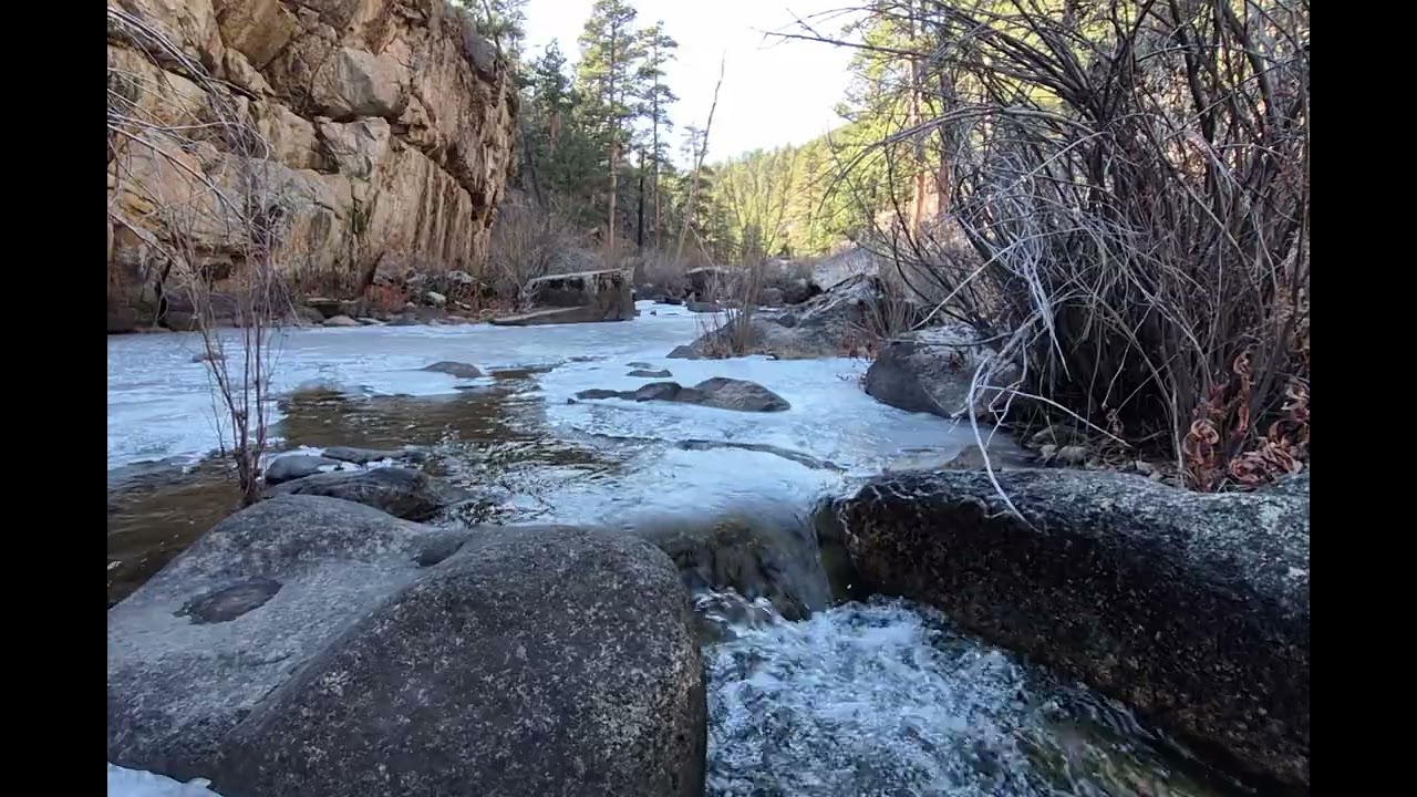 5 MINUTES OF RELAXATION enjoy the water cascading down a rock in a partially frozen mountain creek.