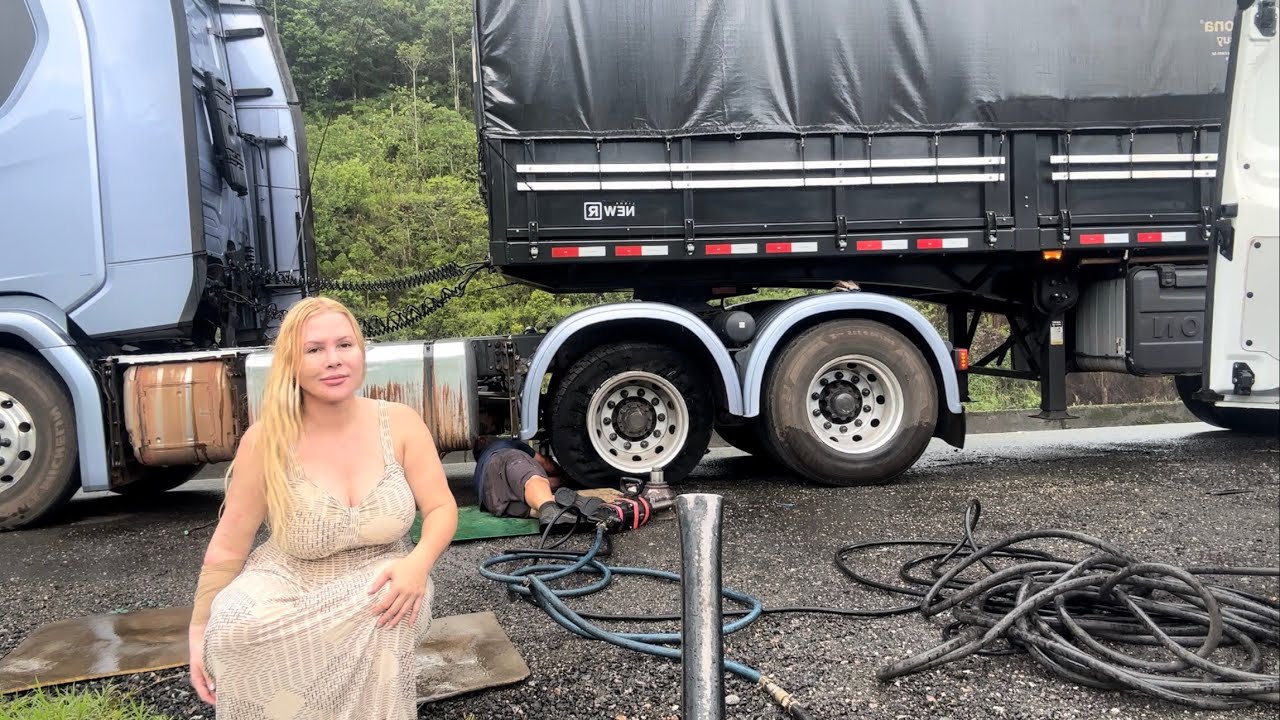 Caminhoneira: trocando os pneus embaixo de chuva na estrada
