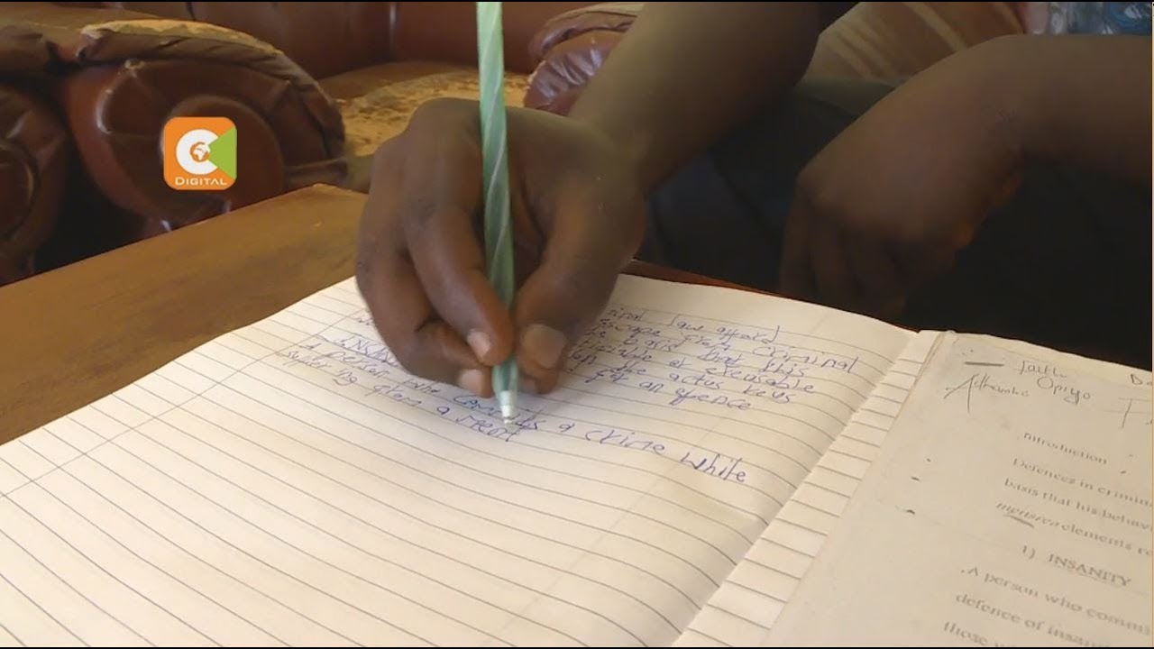 Mwanafunzi anayeandika akiwa amegeuza kitabu