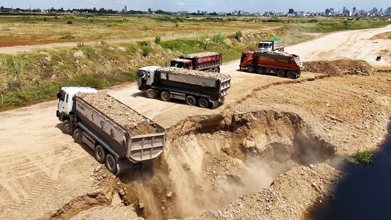 The Extremely Land Filling Operation Bulldozer Pushing Soil & Stone To Water Vs Dump Truck Unloading