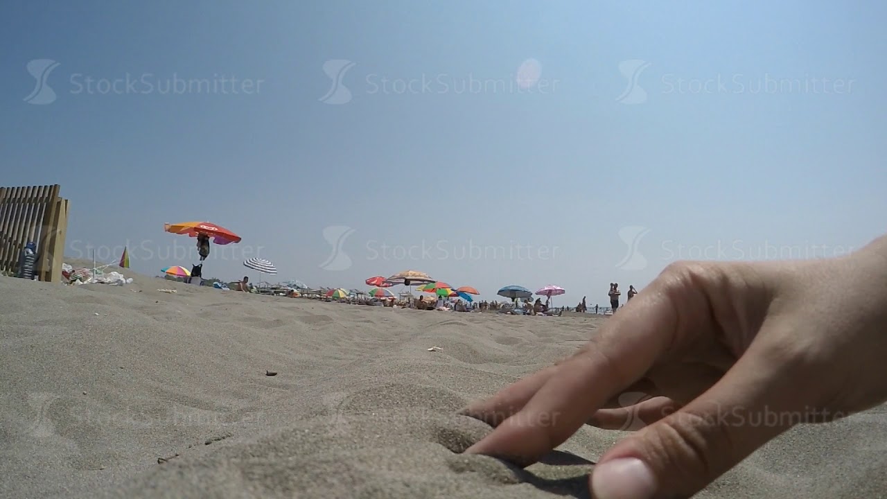 girl having fun beach lifestyle touching pouring sand music video