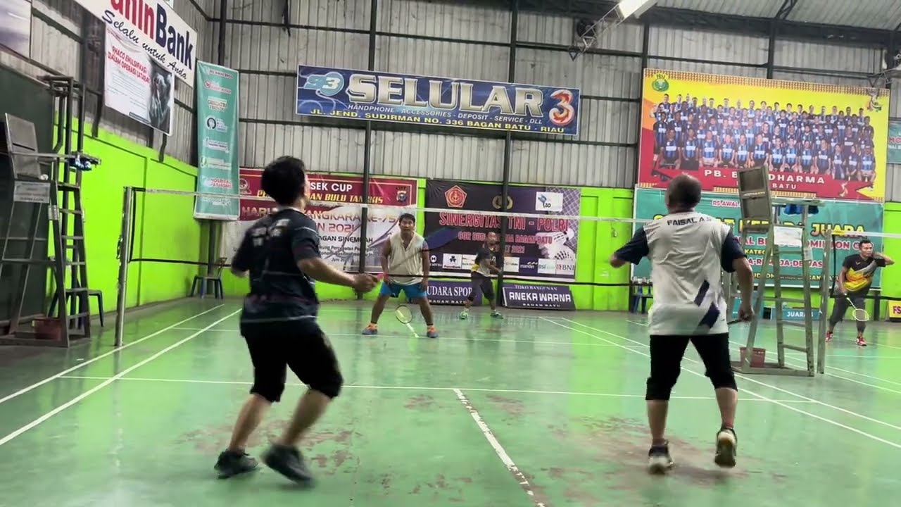 Pertandingan seru pemain bulu tangkis profesional memperebutkan piala panitia.
