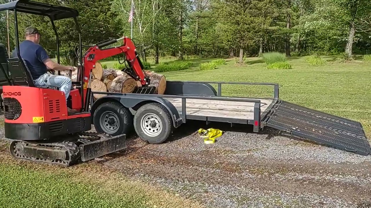 Gardner's Groundhog mini excavator loading fire wood on a trailer.