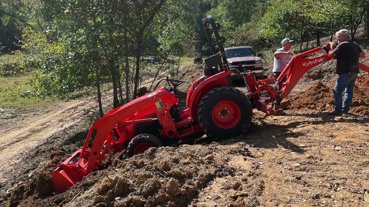 kubota l3901 with Bh77 (backhoe) takes on a steep bank.