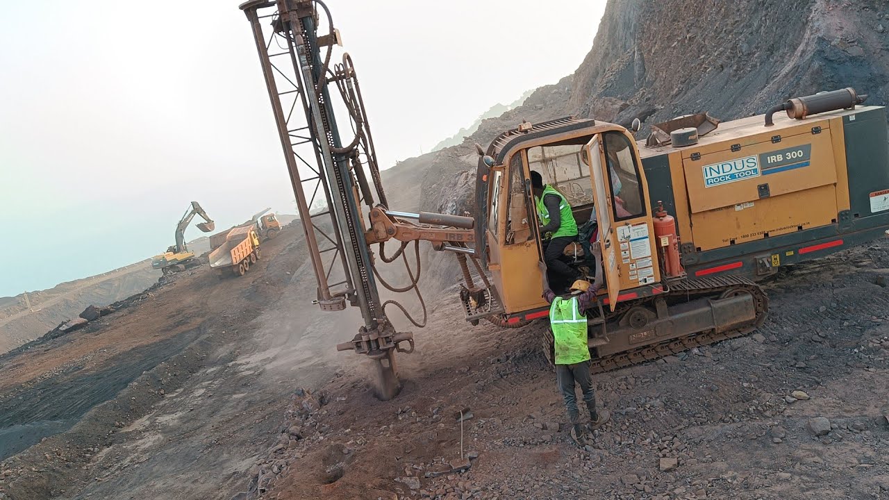 Drill machine at hill top, Drilling at hilly, Drill machine working at iron ore rock hill