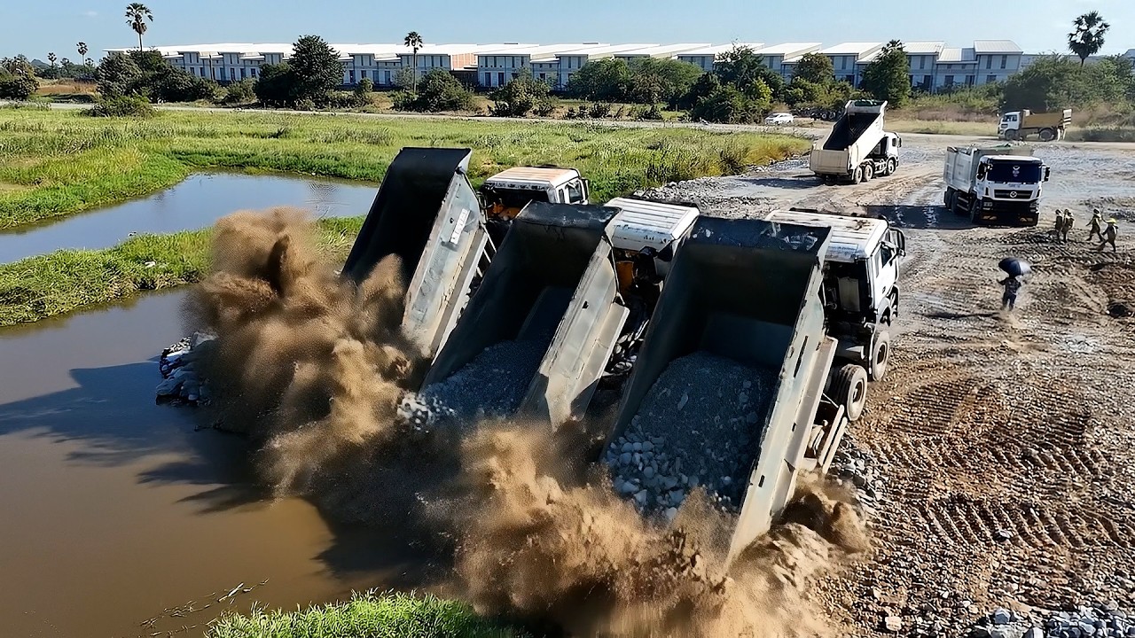 Massive Land Reclamation Process &ndash; Bulldozer Pushing Stone Into Water | Dump Trucks Unloading