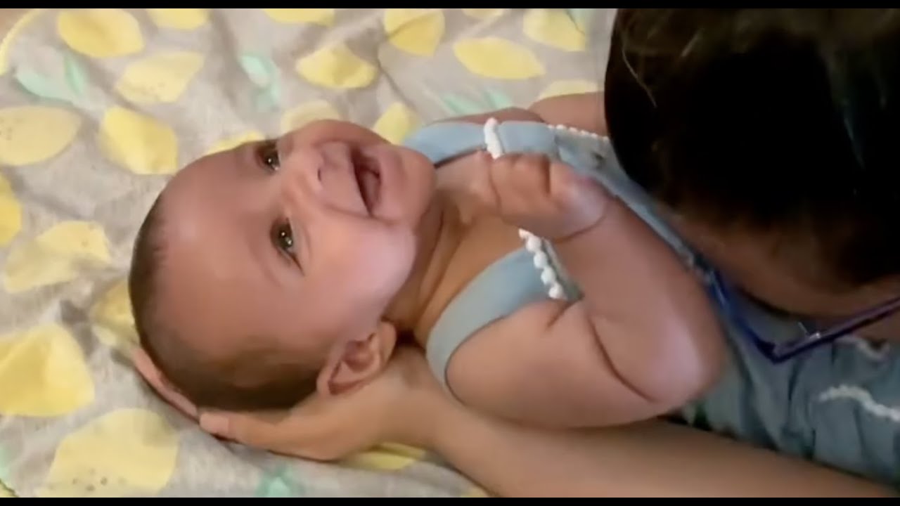 Baby smiles and giggles from Mom's belly kisses.