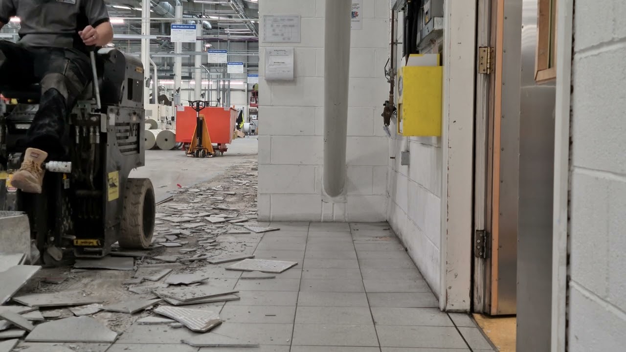 Removing ceramic flooring tiles and tile adhesive with Ride-On floor scraper.