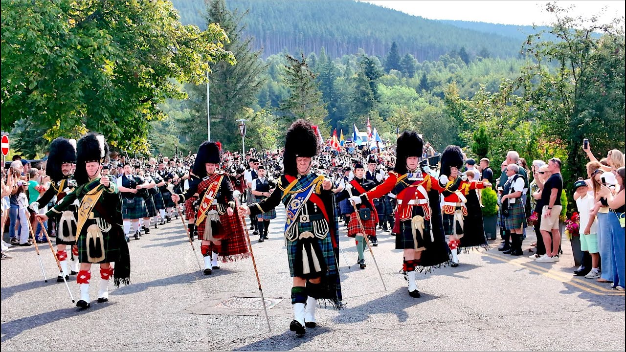Drum Majors lead massed Pipes and Drums march over bridge to 2025 Ballater Highland Games, Scotland