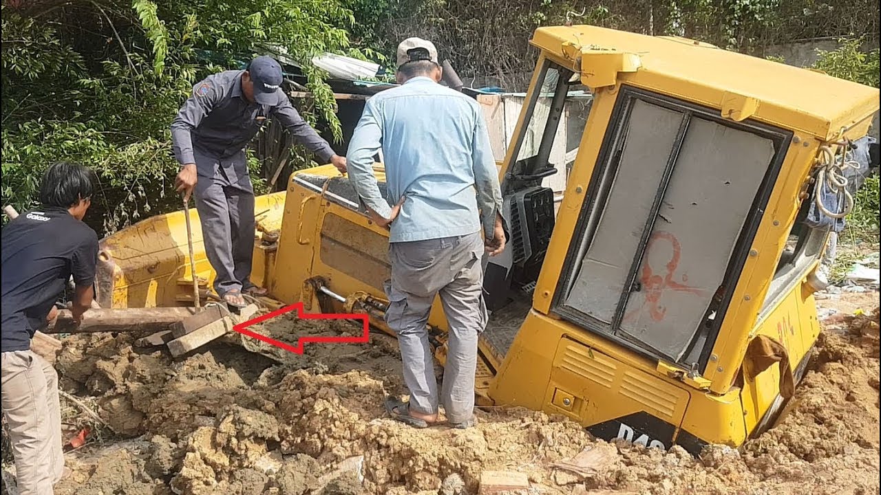Operator technique skills try to recovery bulldozer D4G from deep mud