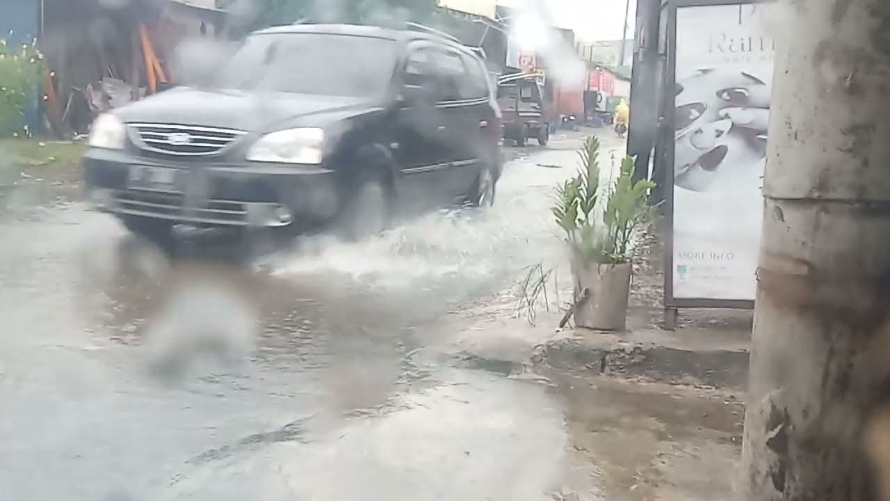 Aktivitas orang orang saat hujan awet jalan banjir.