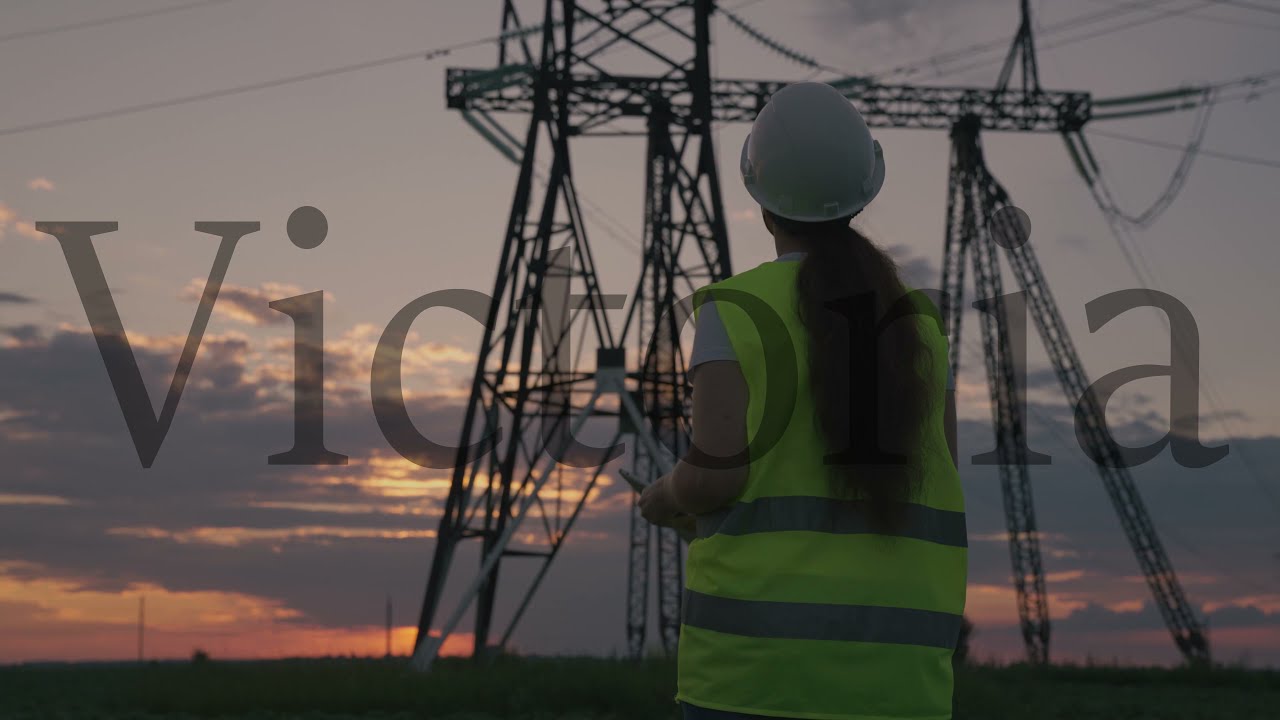 young woman in hardhat head of power station towers. energy business concept. woman power engineer