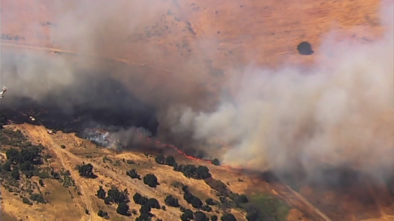 Crews battling brush fire near homes in California