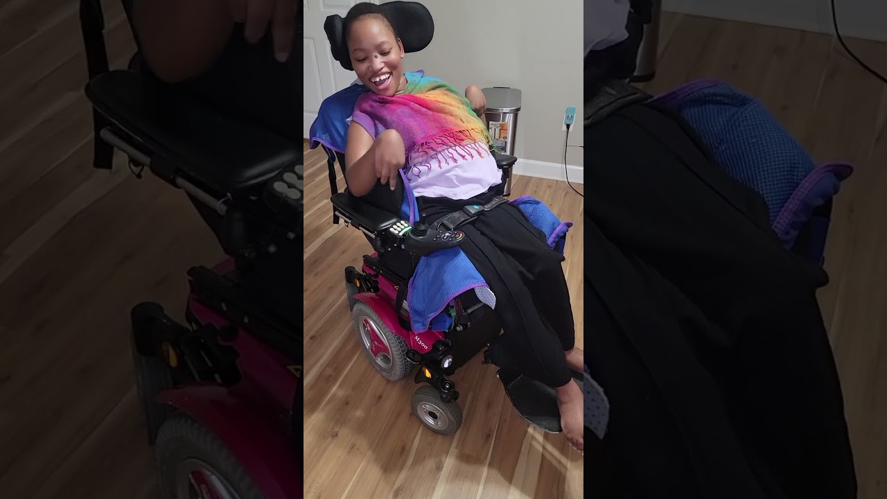 Maria driving her power wheelchair with the joystick 🕹