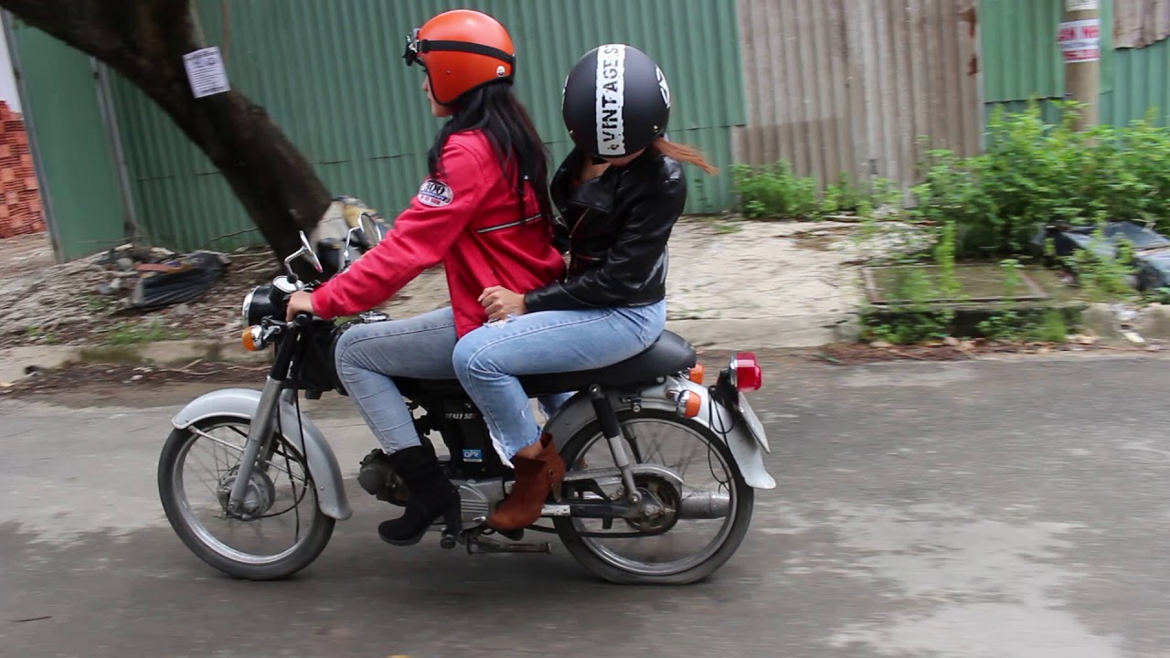 TWo girls on old moped with flat tire