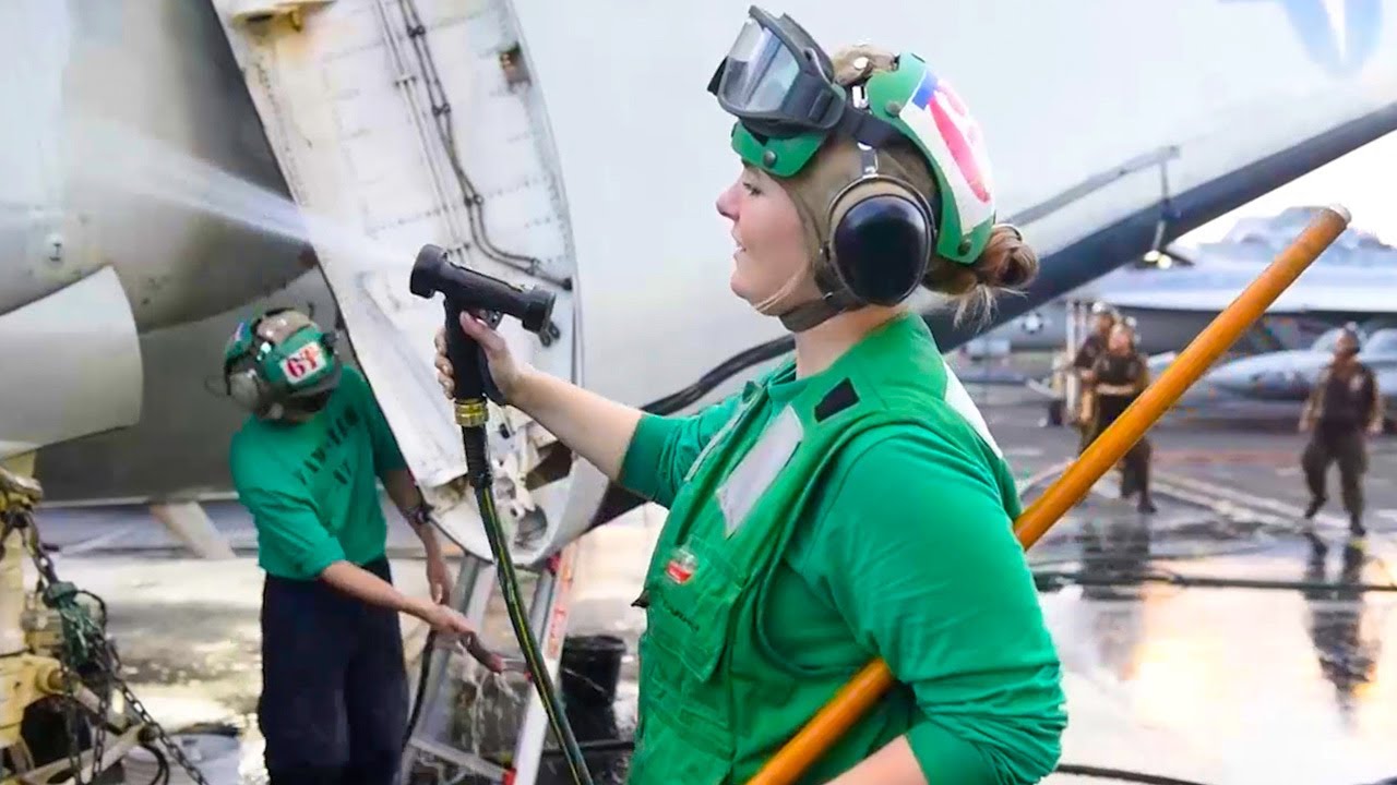 US Navy Sailors Wash E-2C Hawkeye Aboard Aircraft Carrier