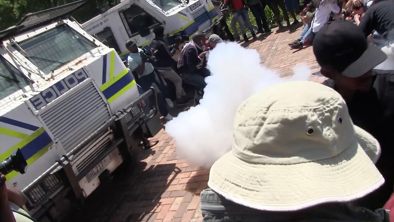 Police fire stun grenades at close range towards seated students