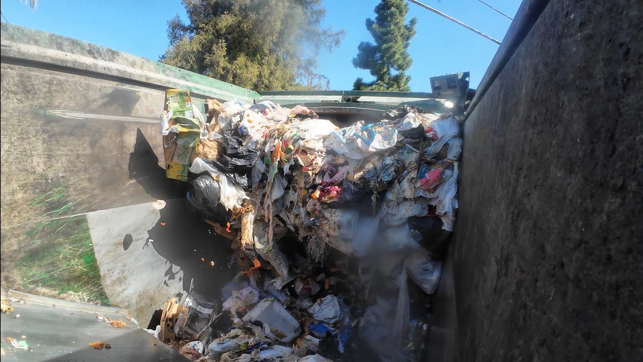 Waste Management front load commercial garbage truck packer view