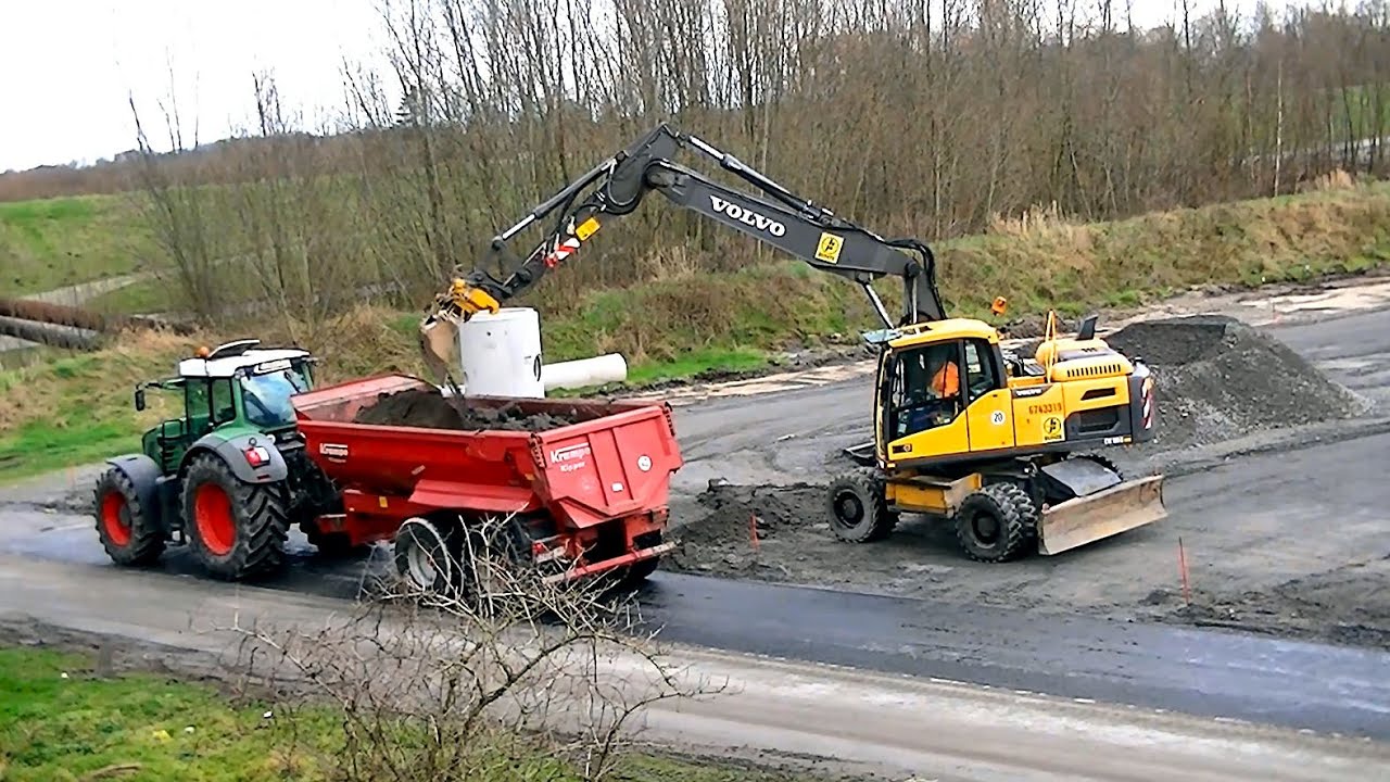 Parkplatzbau: Volvo EW180D lädt Traktorgespann / Wheeled excavator Volvo EW180D
