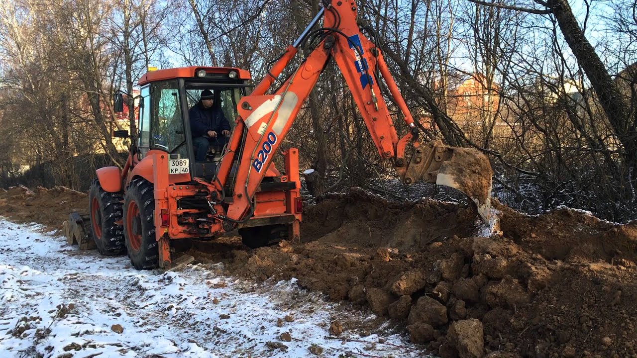 Экскаватор погрузчик Fiat Kobelco B200 закапывает траншею в Калуге